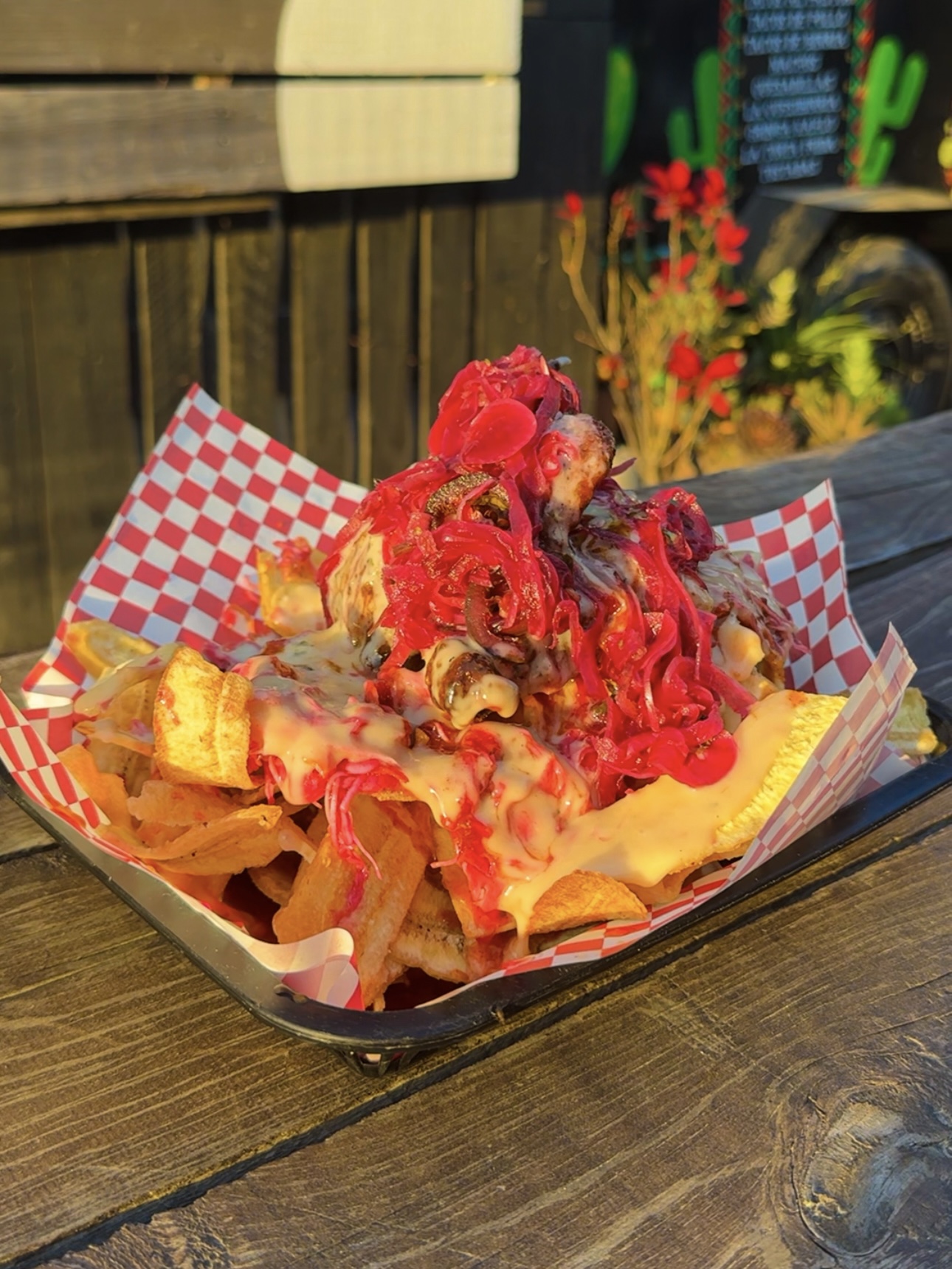 Nachos cargados con repollo morado, queso fundido y salsas.